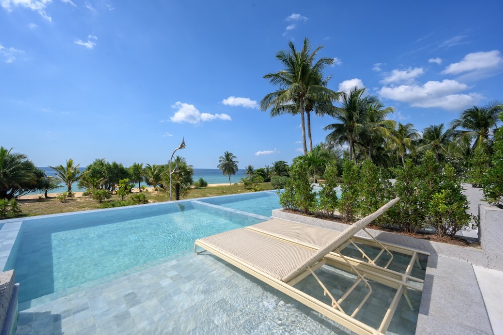 Swimming pool surrounded by palm trees at Thavorn Palm Beach, a MICE hotel in Phuket