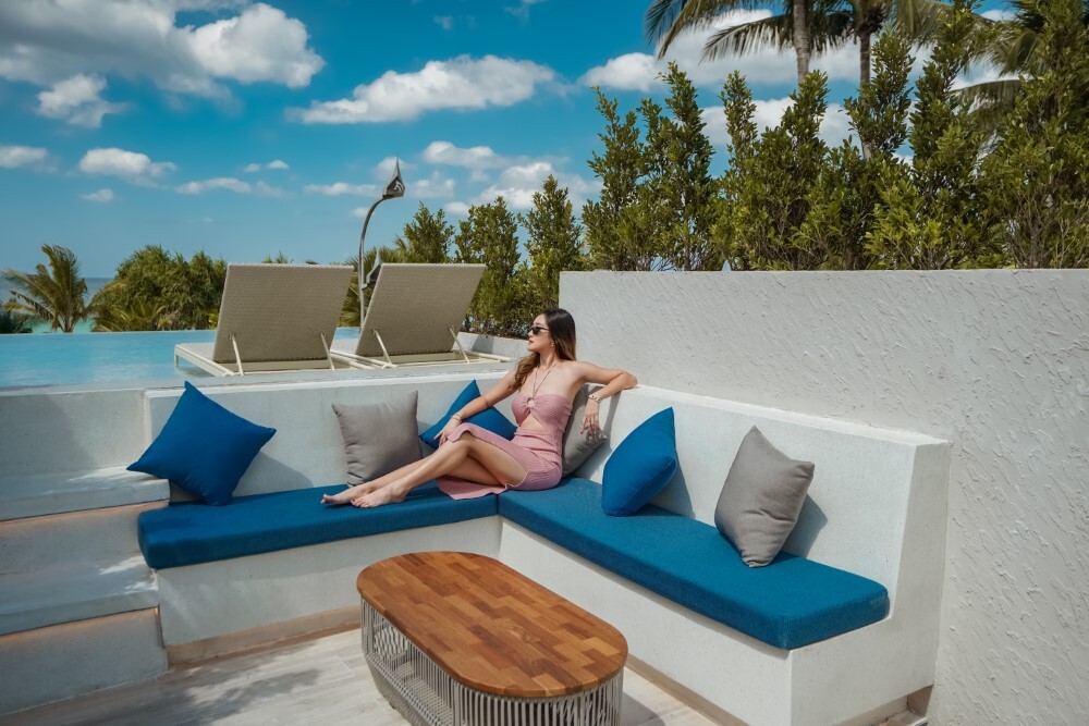 Woman relaxing on her private terrace at Thavorn Palm Beach, a MICE hotel in Phuket