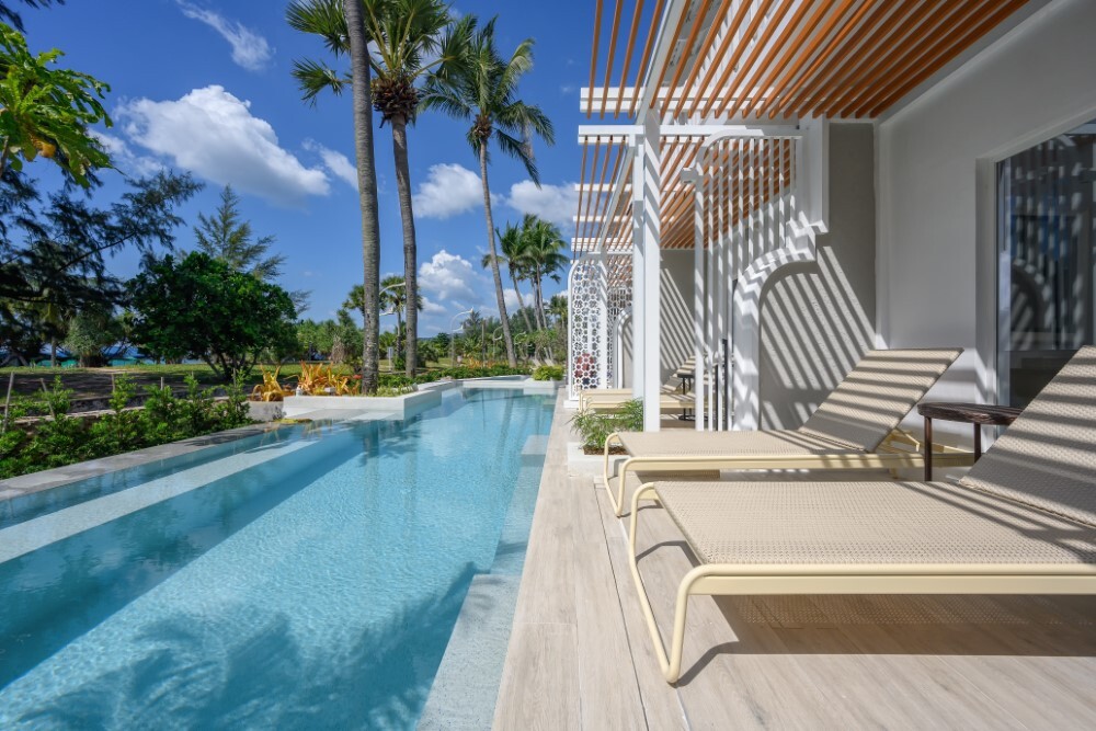 Guest suite living area with pool view at Thavorn Palm Beach, a MICE hotel in Phuket