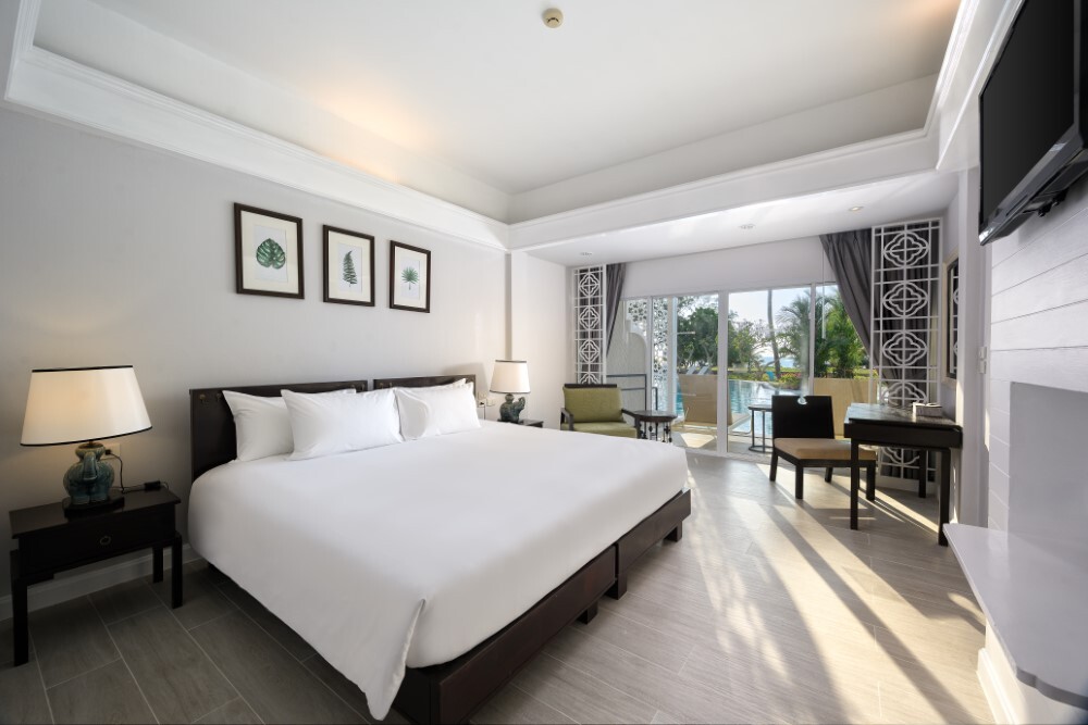 Guest suite living area with pool view at Thavorn Palm Beach, a MICE hotel in Phuket