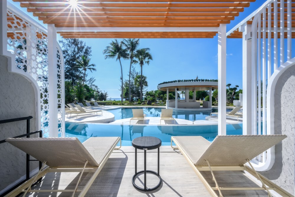Pool access terrace with sun loungers at Thavorn Palm Beach, a MICE hotel in Phuket