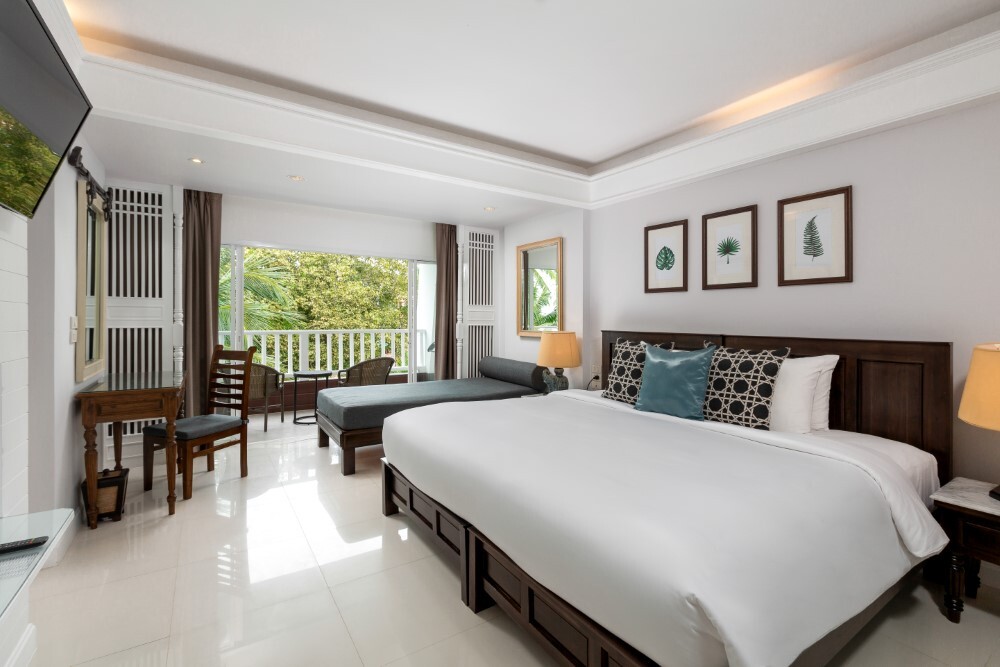 Deluxe room featuring a large bed and work desk at Thavorn Palm Beach, a MICE hotel in Phuket